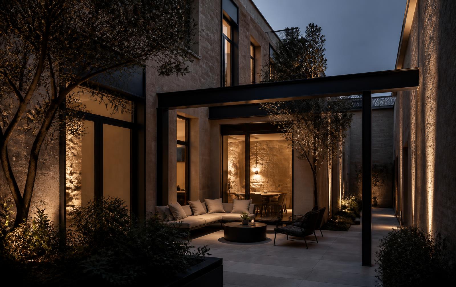 Dusk courtyard of an elegant residence with warm interior lighting